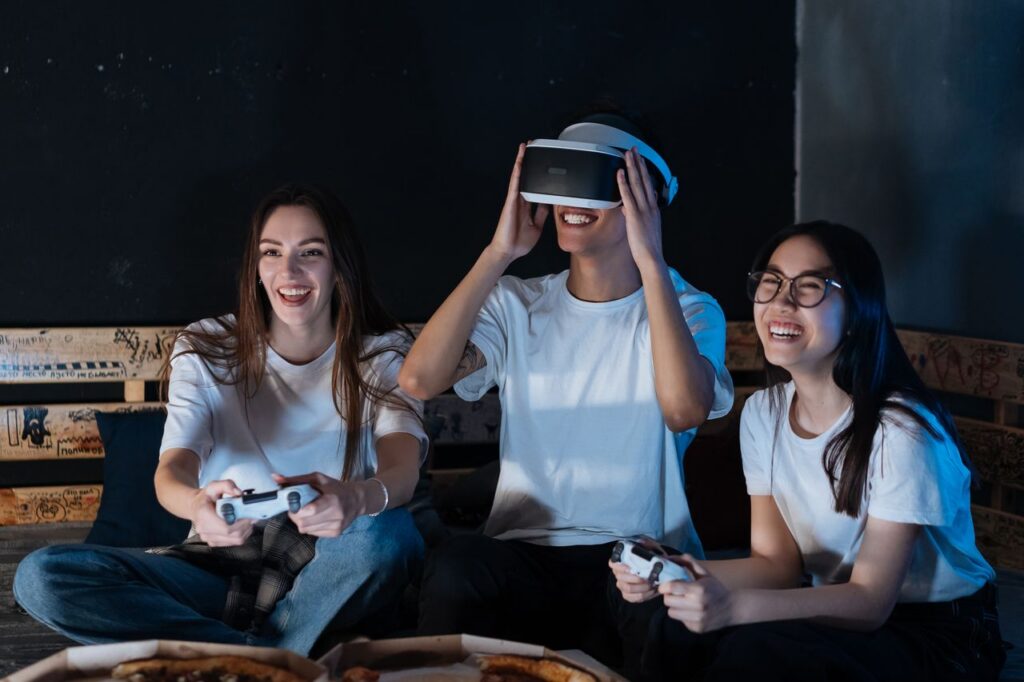 Group of friends having fun with VR gaming. Laughter, technology, and bonding moments indoors.